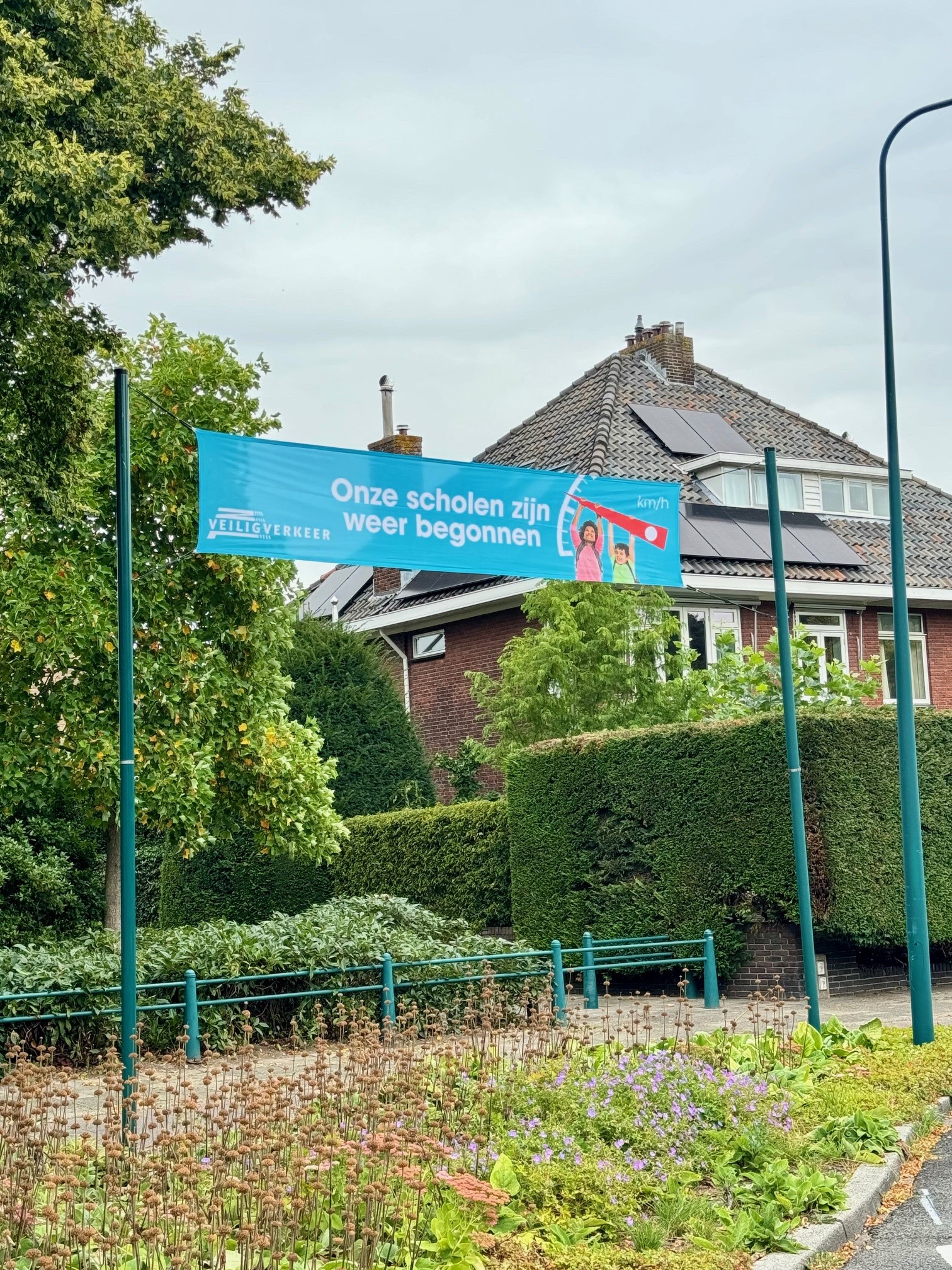 spandoek in straat met boodschap ‘Onze scholen zijn weer begonnen’