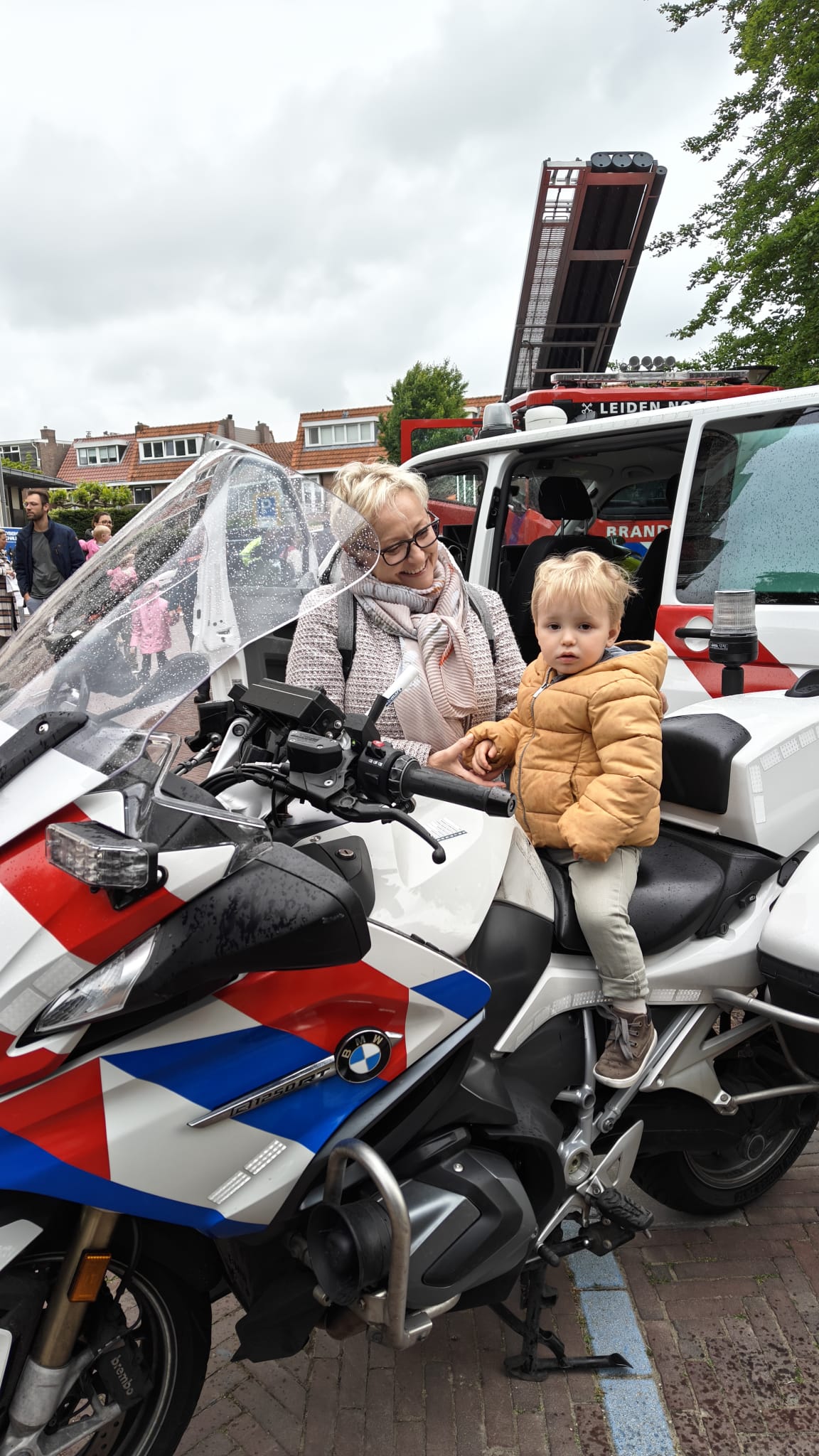 Op de foto staat een klein meisje op een politiemotor