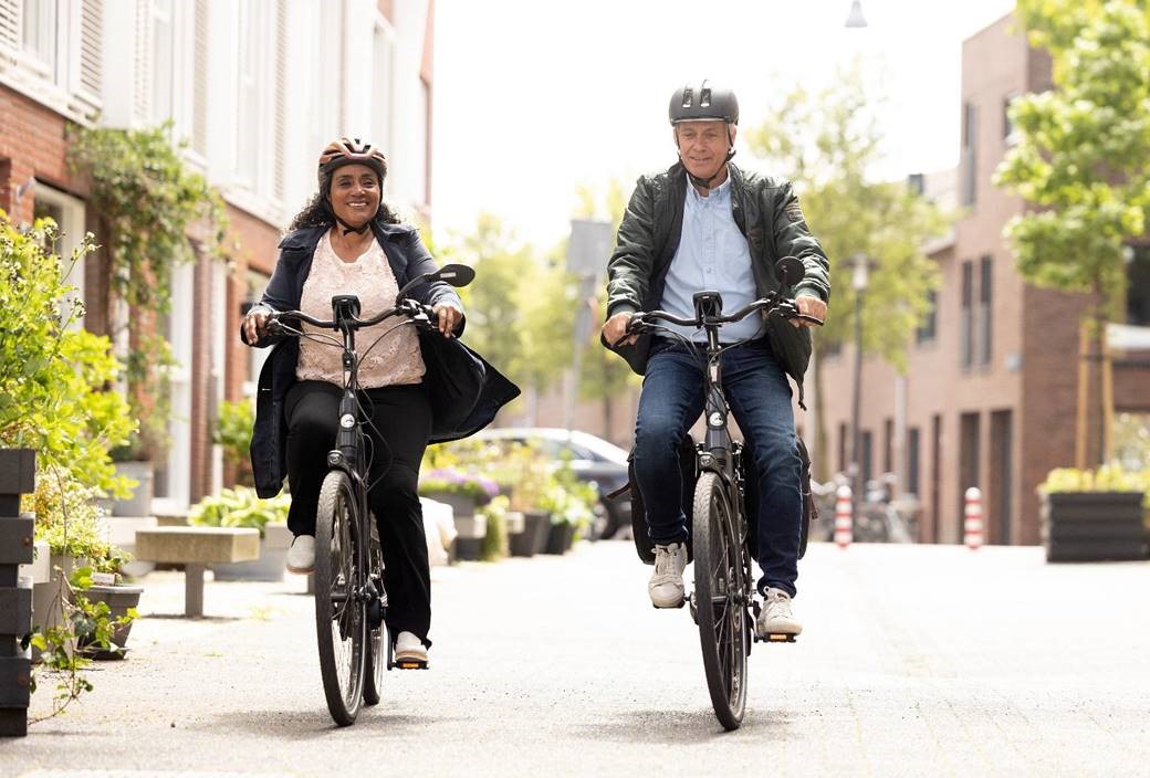 Afbeelding van twee fietsende mensen met fietshelm.