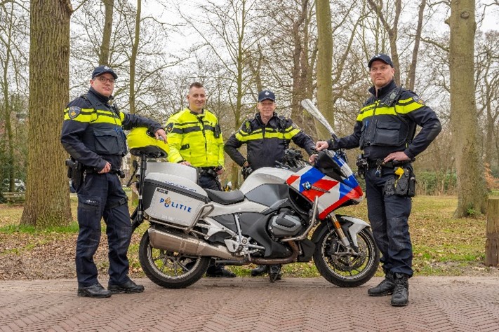 Afbeelding van vier wijkagenten uit Oegstgeest die naast een politie motorfiets staan. V.l.n.r.: Pieter Brussee, Dennis Krom, John Welboren, Jeen Brinksma