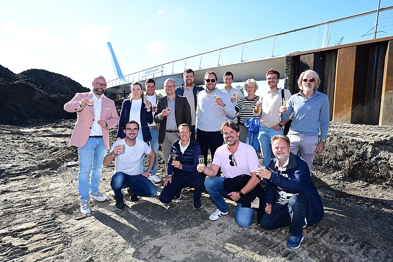 Alle betrokkenen bij start van de bouw van het horecapaviljoen proostend bij elkaar 